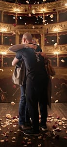 due attori si abbracciano sul palco di un teatro